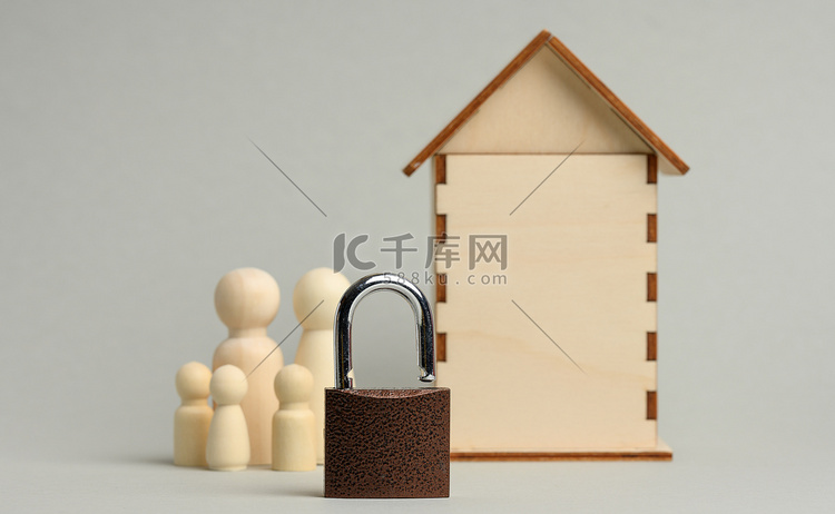 木制微型房屋背景上的金属挂锁和