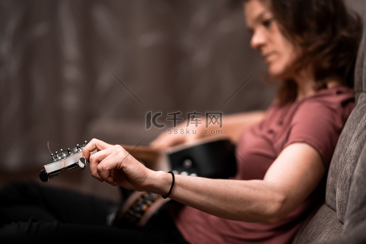 在家沙发上调吉他的女人