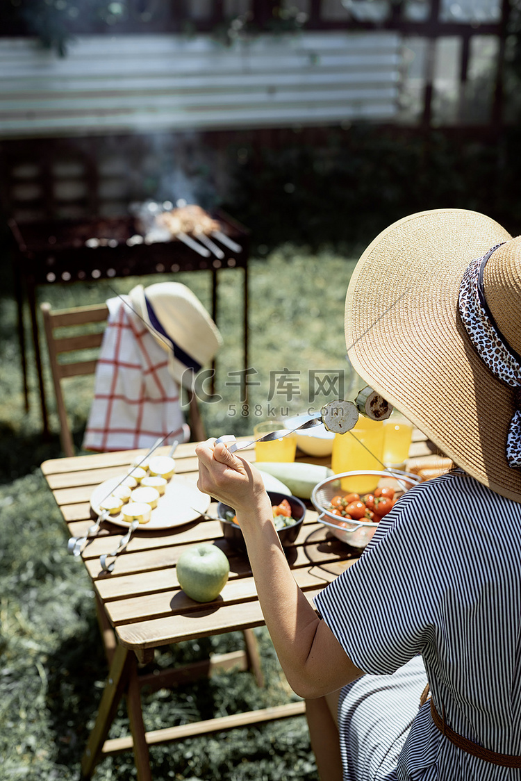 戴着夏日帽子的年轻女人坐在桌边