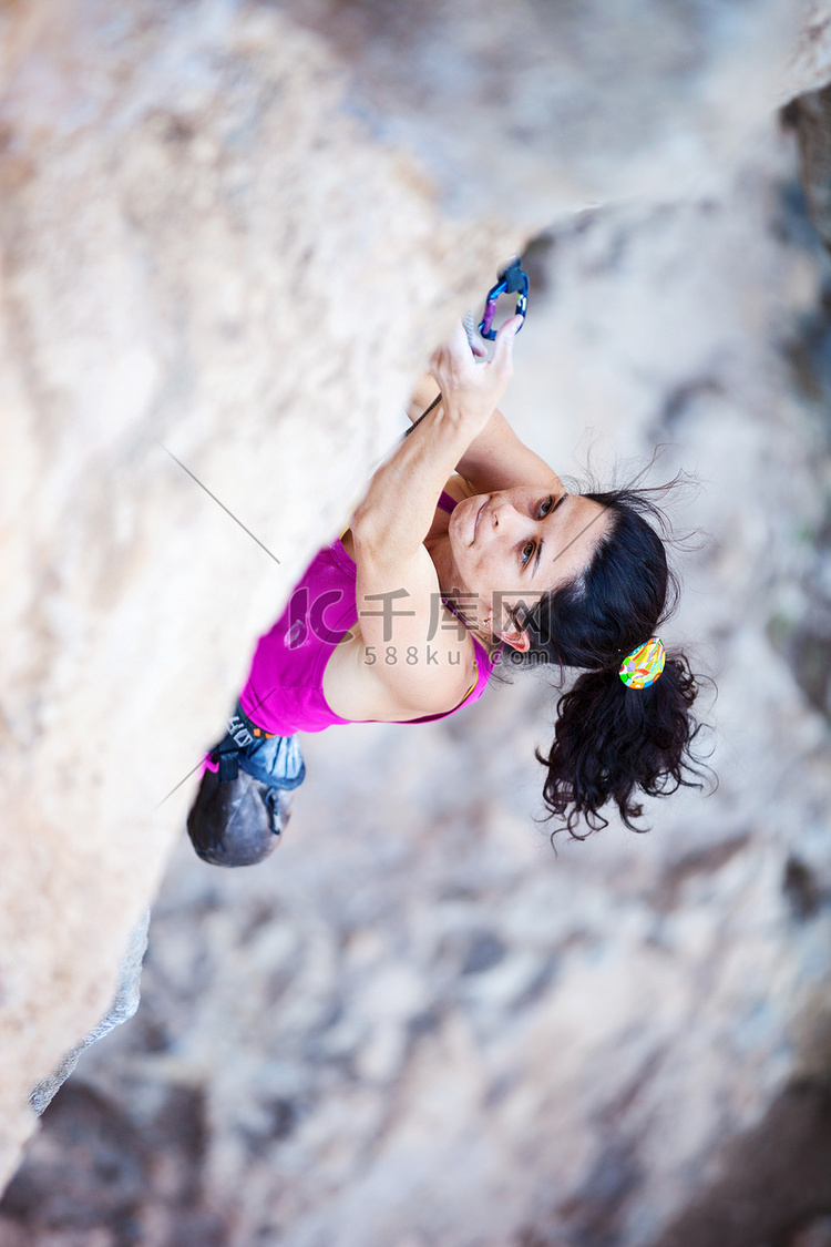 峭壁的年轻女性攀岩者
