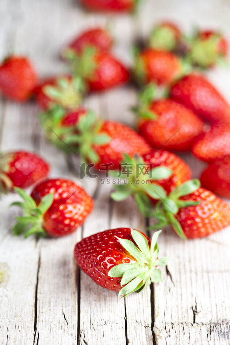 质朴的木制背景上的新鲜红草莓。