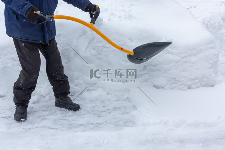 大雪过后，一个男人用铲子清理院