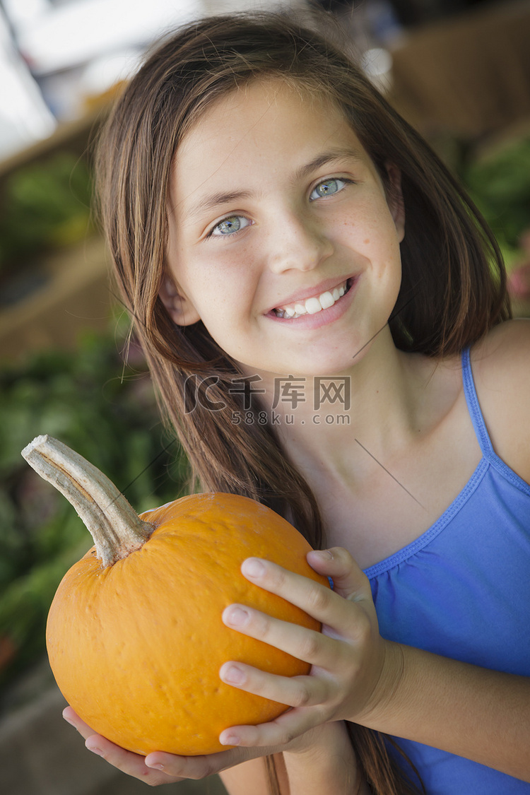 漂亮的年轻女孩在市场上玩南瓜