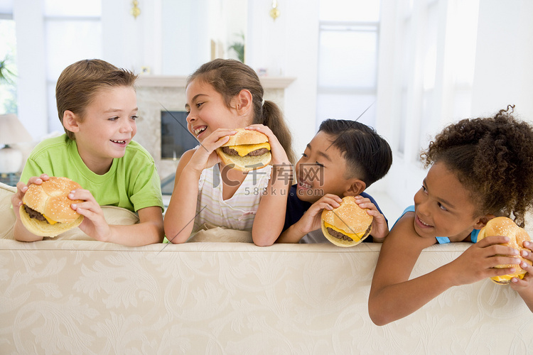 四个小孩在客厅里微笑着吃芝士汉