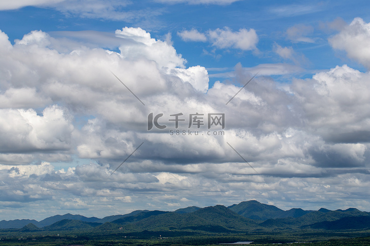 蓝天和山背景中的白色蓬松云