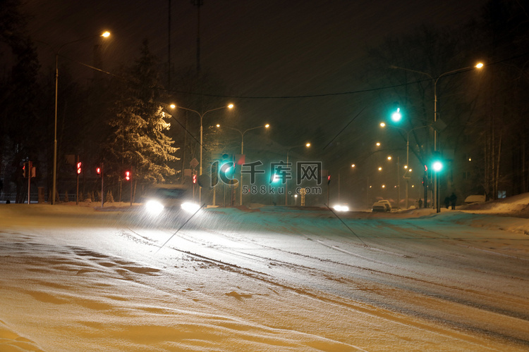 下雪的冬季道路，汽车在暴风雪中