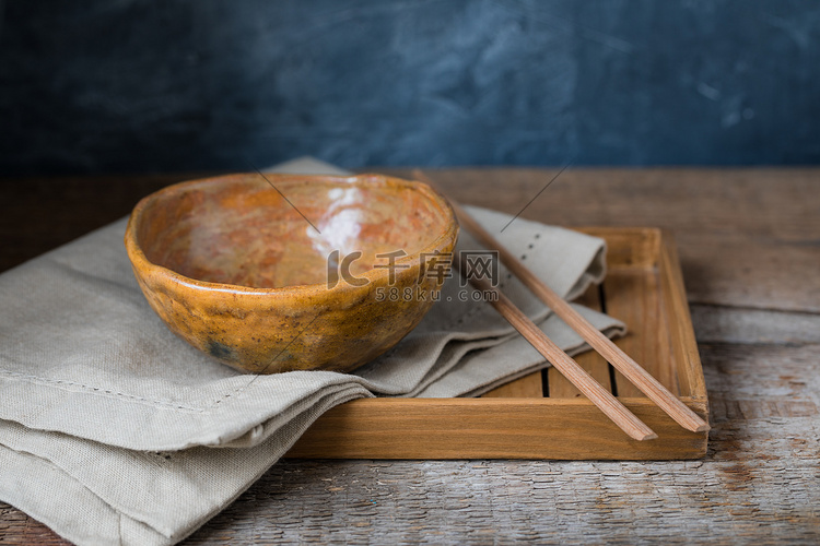 木制背景上的手工陶瓷碗，侘寂风