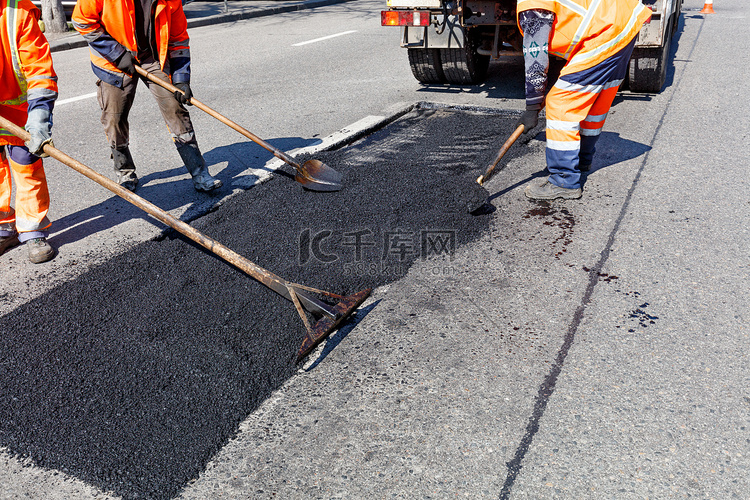 工人大队在道路施工中用铲子清理