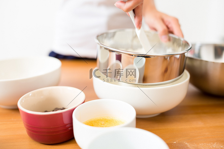 女人用碗里的筛子筛面粉