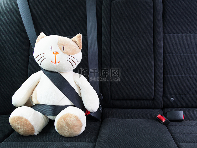 毛绒玩具猫用安全带固定在汽车后