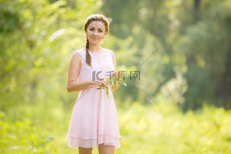 一个年轻女孩在草地上采花的肖像