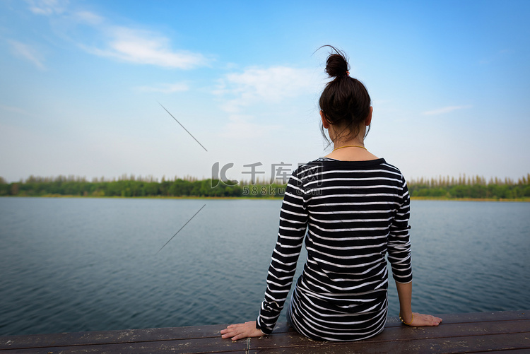 女人在泳池边的长椅上享受大自然