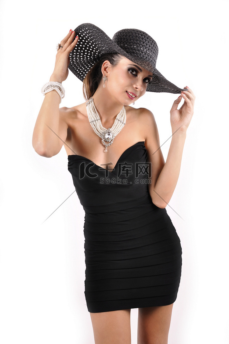 佩带黑礼服、帽子和珍珠的可爱的