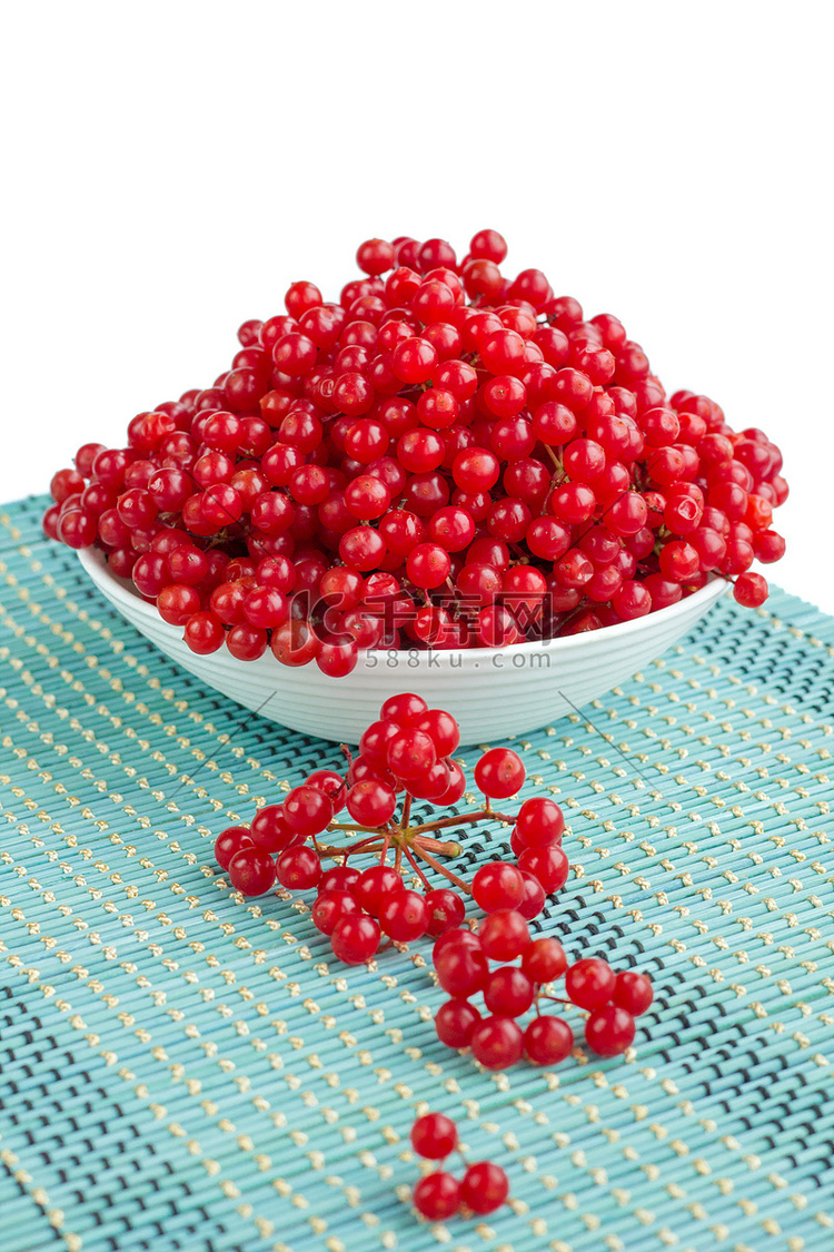 白色盘子中的红色荚莲属植物浆果