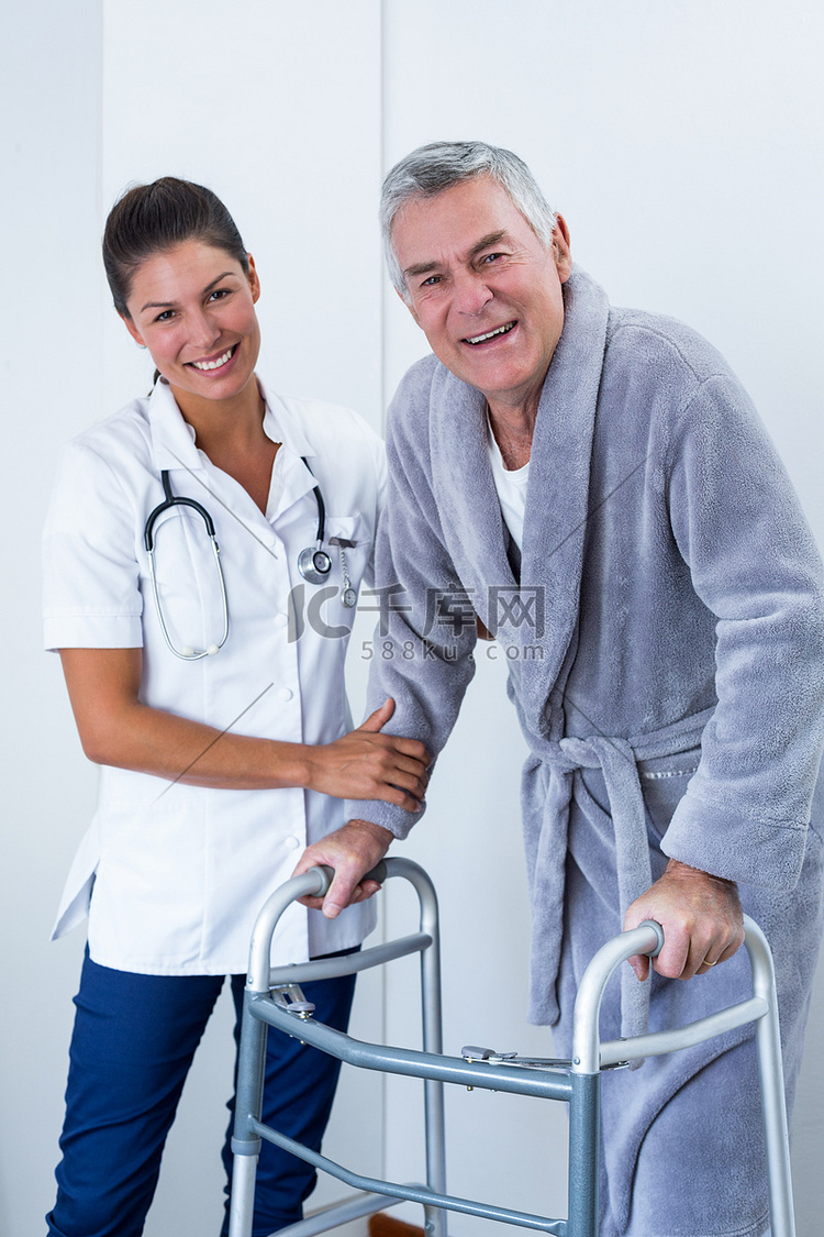 帮助老人与助行器一起行走的女医