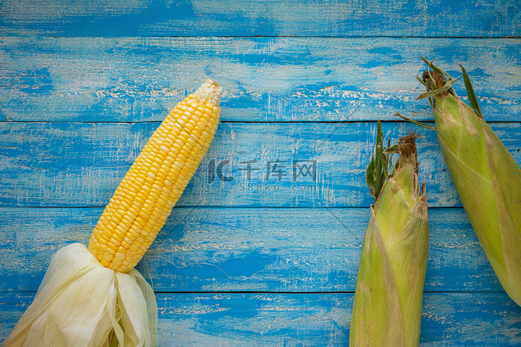在一张蓝色木桌顶视图的成熟玉米