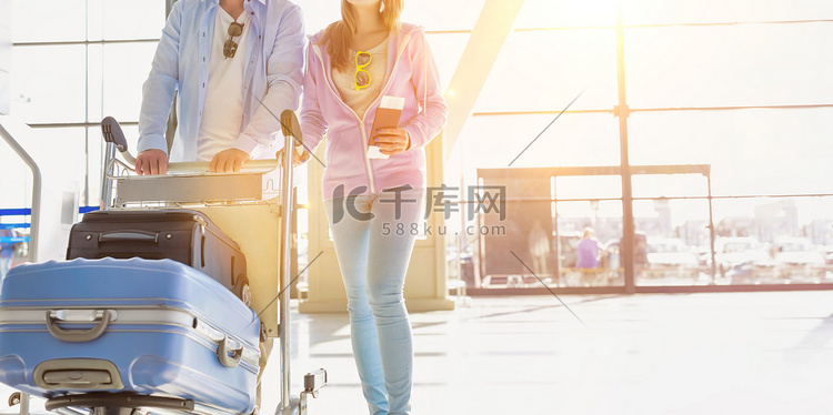 男子推行李车与女儿在机场办理登