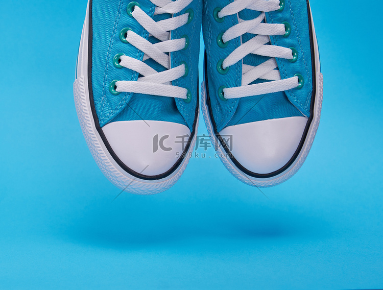 一双带白色鞋带的蓝色纺织运动鞋