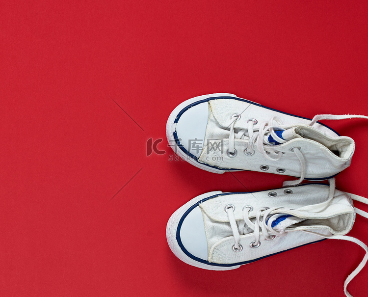 一双带解开鞋带的白色旧纺织运动