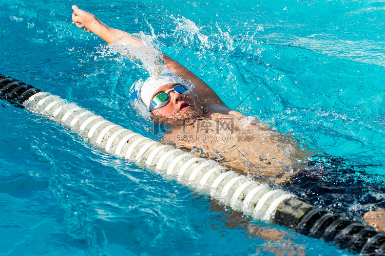 青少年仰泳游泳运动员在行动。