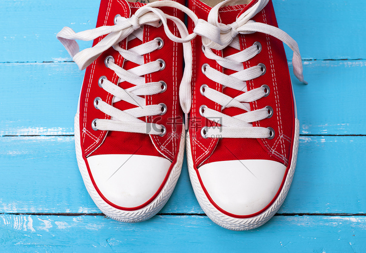 一双带白色鞋带的红色纺织运动鞋