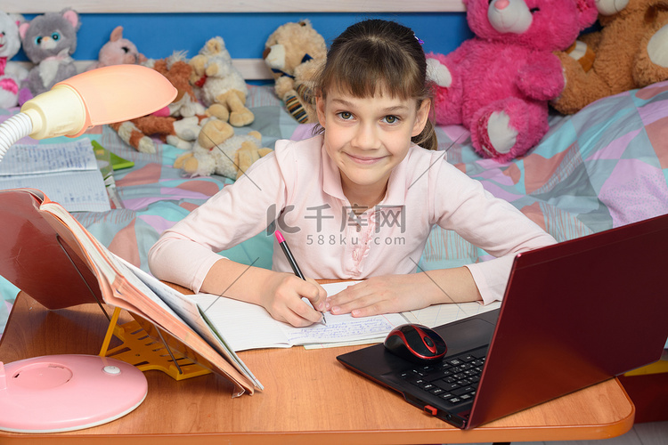 一个孩子在家里的书桌前学习，背
