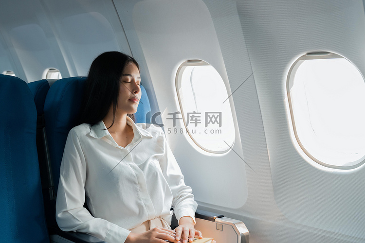 乘飞机旅行的女乘客睡在坐垫飞机