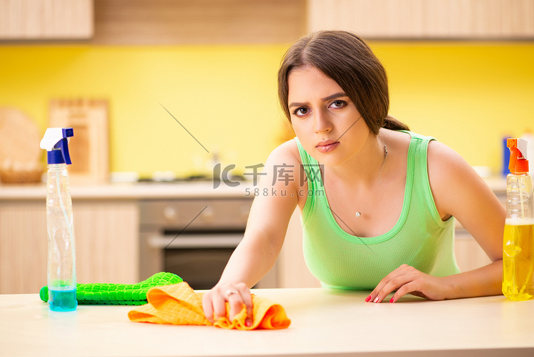 年轻漂亮的女人在厨房里擦桌子