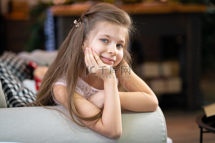 一个小女孩躺在沙发上，靠在手臂