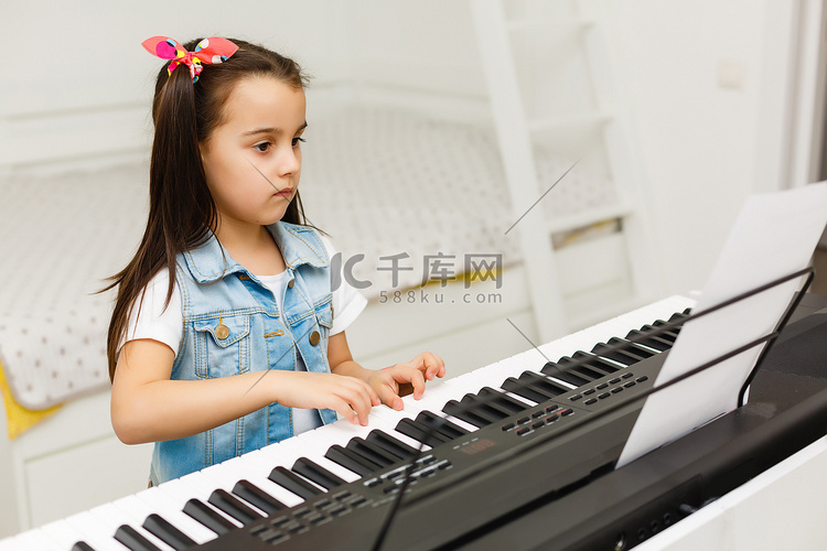 有钢琴键盘的快乐小女孩