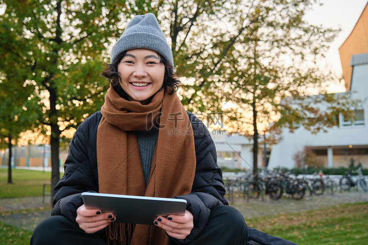 亚洲女孩在公园里放松、观看视频