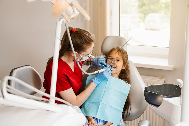 儿科牙医检查并咨询牙科儿童患者