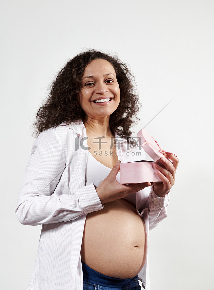漂亮的孕妇对着镜头微笑，为母亲