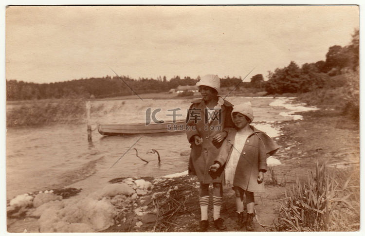 老式照片显示两个女孩沿着河边走