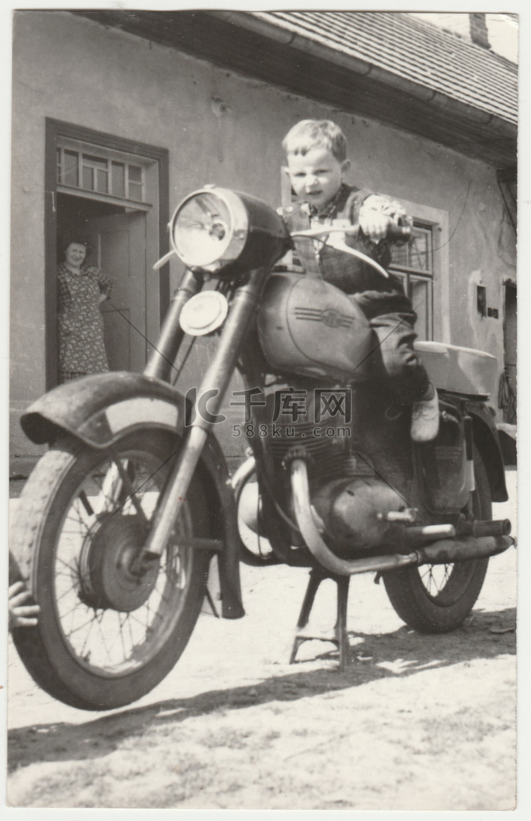 老式照片显示男孩坐在老式摩托车