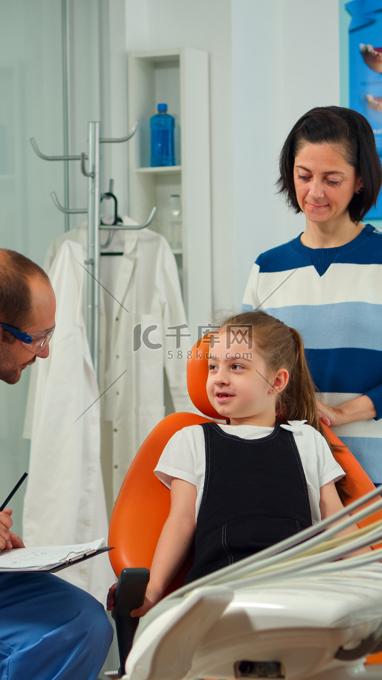 友好的男牙医助理审问儿童病人