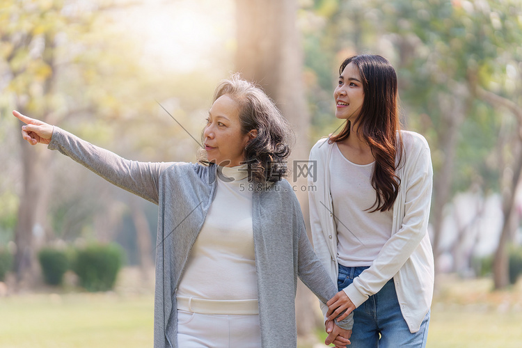 成年女儿用爱牵着年迈母亲的手一