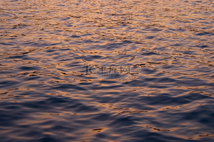 深色的海水反射出夕阳天空的赭色