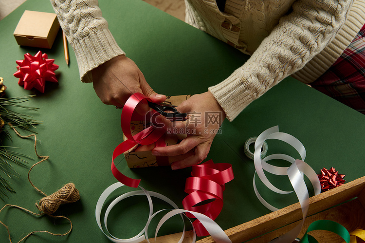 一名妇女包装圣诞礼物，用红色闪