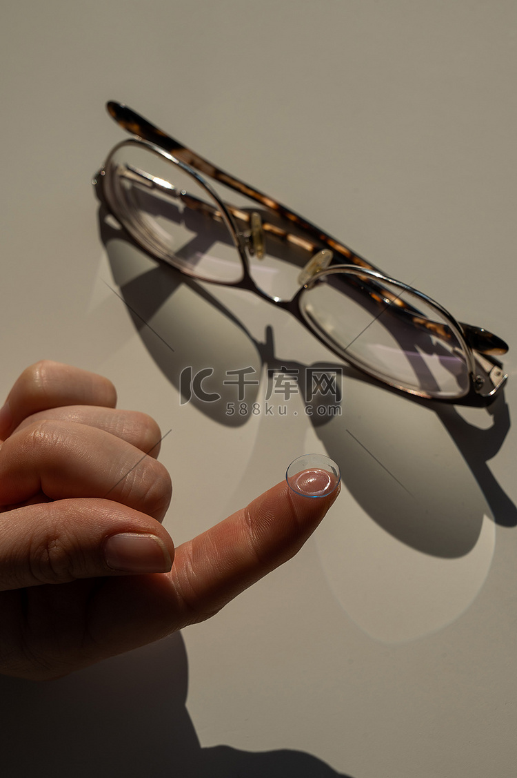 女性食指上隐形眼镜的特写镜头，