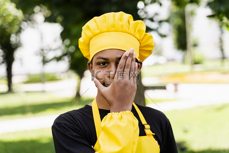 非洲黑人青少年戴着厨师帽，穿着