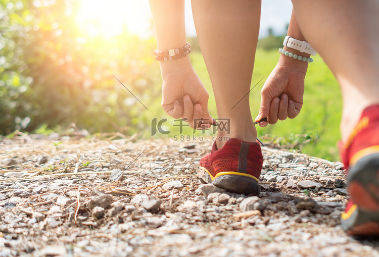 女人穿跑鞋在自然绿色背景下行走