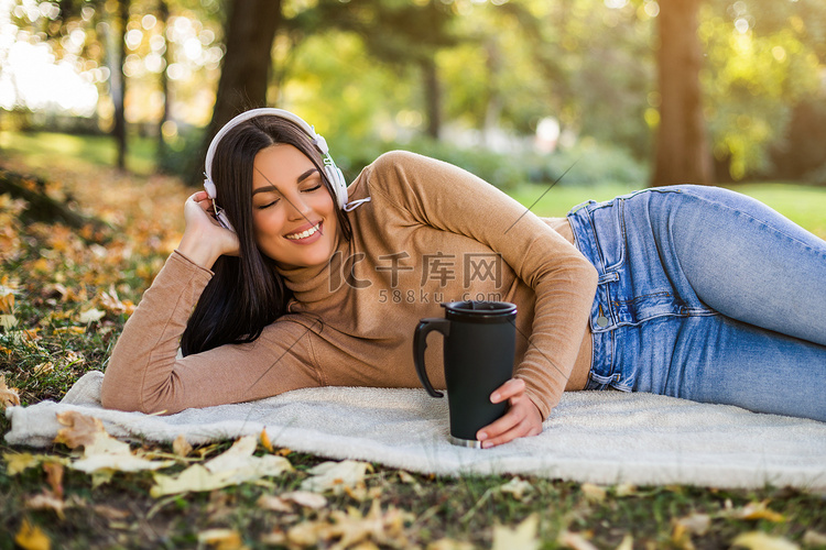 女人一边听音乐，一边喝咖啡，一