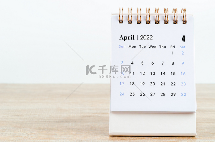 2022 年 4 月日历在木桌上。