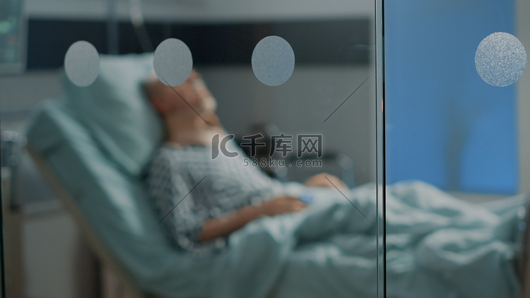 生病的老人躺在医院病床上，颈托