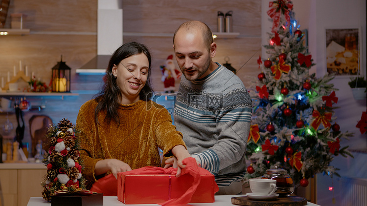男人和女人在圣诞礼物上包红纸