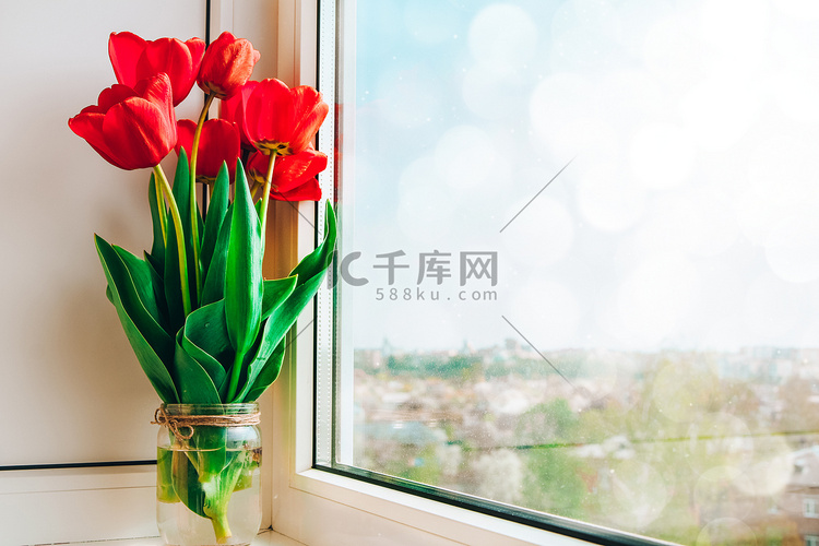 窗台上花瓶中的红色郁金香明亮，