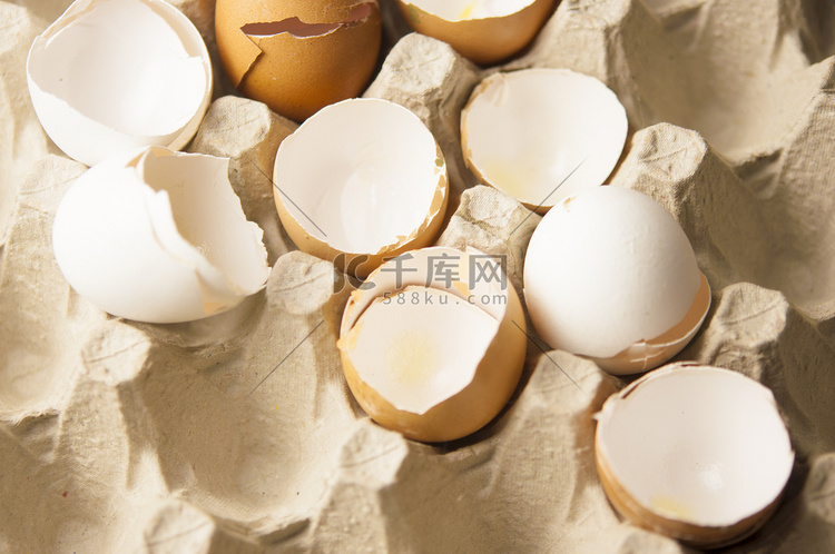 许多带壳鸡蛋散落在由回收废纸制