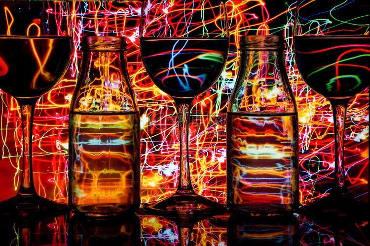 酒杯和瓶子排成一排，后面有彩色