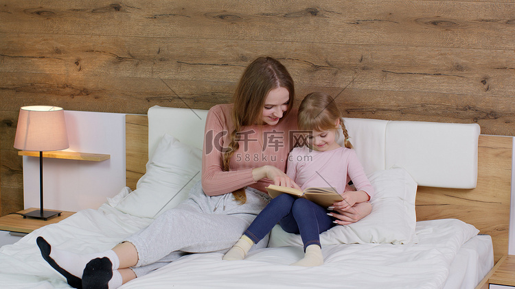 年轻的母亲和孩子的女儿在家躺在